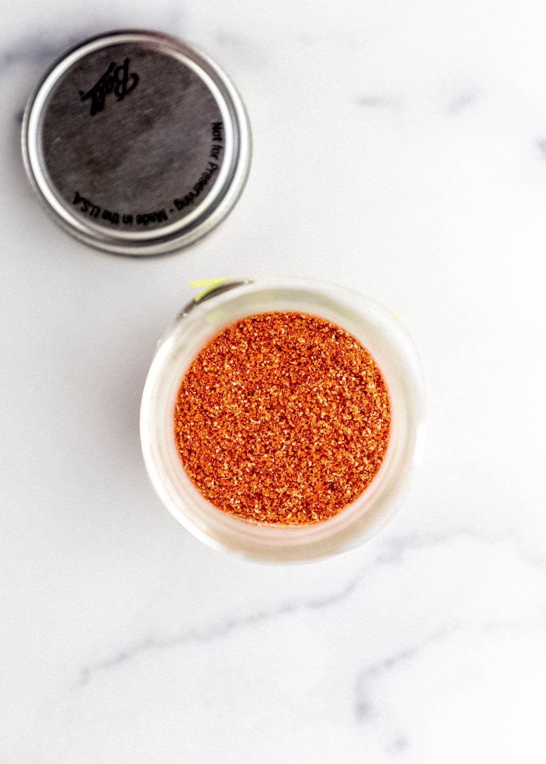 Overhead view of seasoning in small jar by lid.