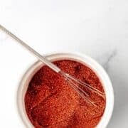 Overhead view of bowl of seasoning and whisk in it on pin with text overlay.