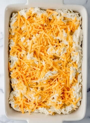 Overhead view of casserole mixture topped with shredded cheese.