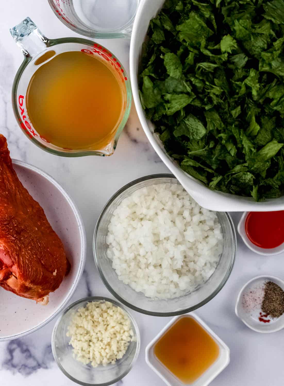 Overhead view of ingredients needed to make greens in separate bowls.