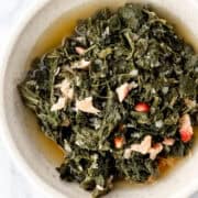 Close up overhead view of greens in a white bowl.