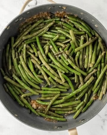 Green beans added to a large skillet with the other ingredients.