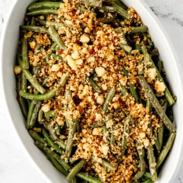 Overhead view of finished green beans in white serving bowl.