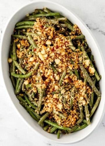 Overhead view of finished green beans in white serving bowl.