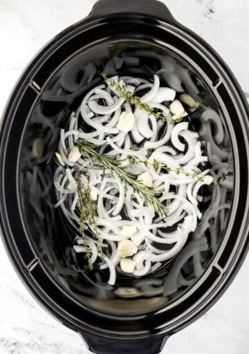 Overhead view of slow cooker with base ingredients in it.