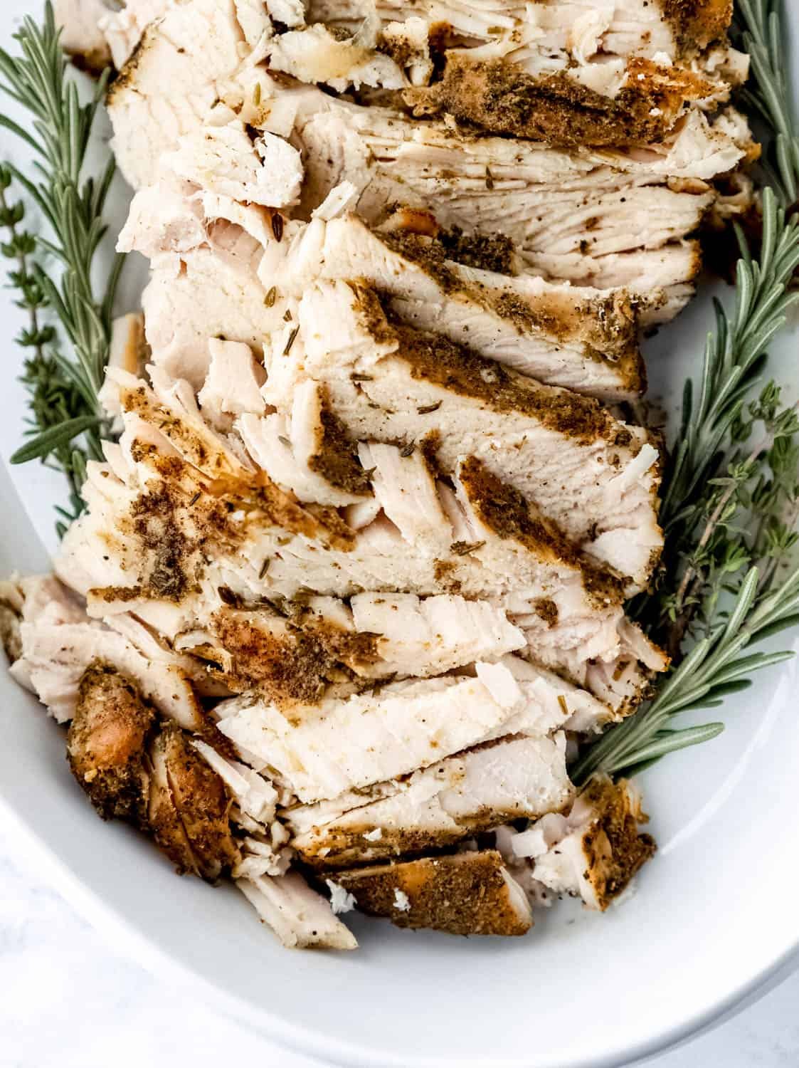 Close up view of turkey in white baking dish. 