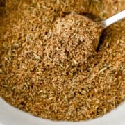 Close up view of seasoning in a white bowl with a spoon.