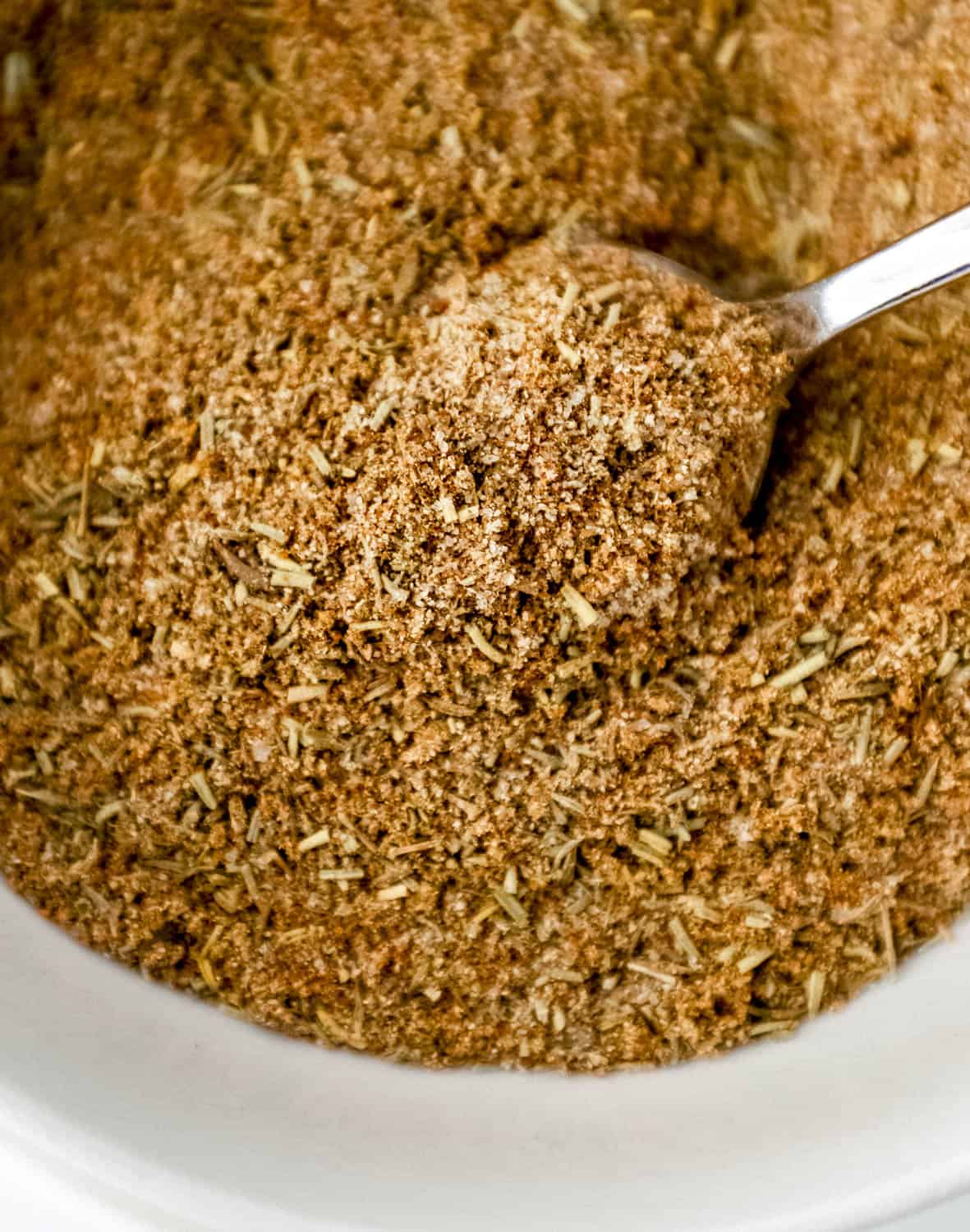 Close up view of seasoning in a bowl with a spoon. 