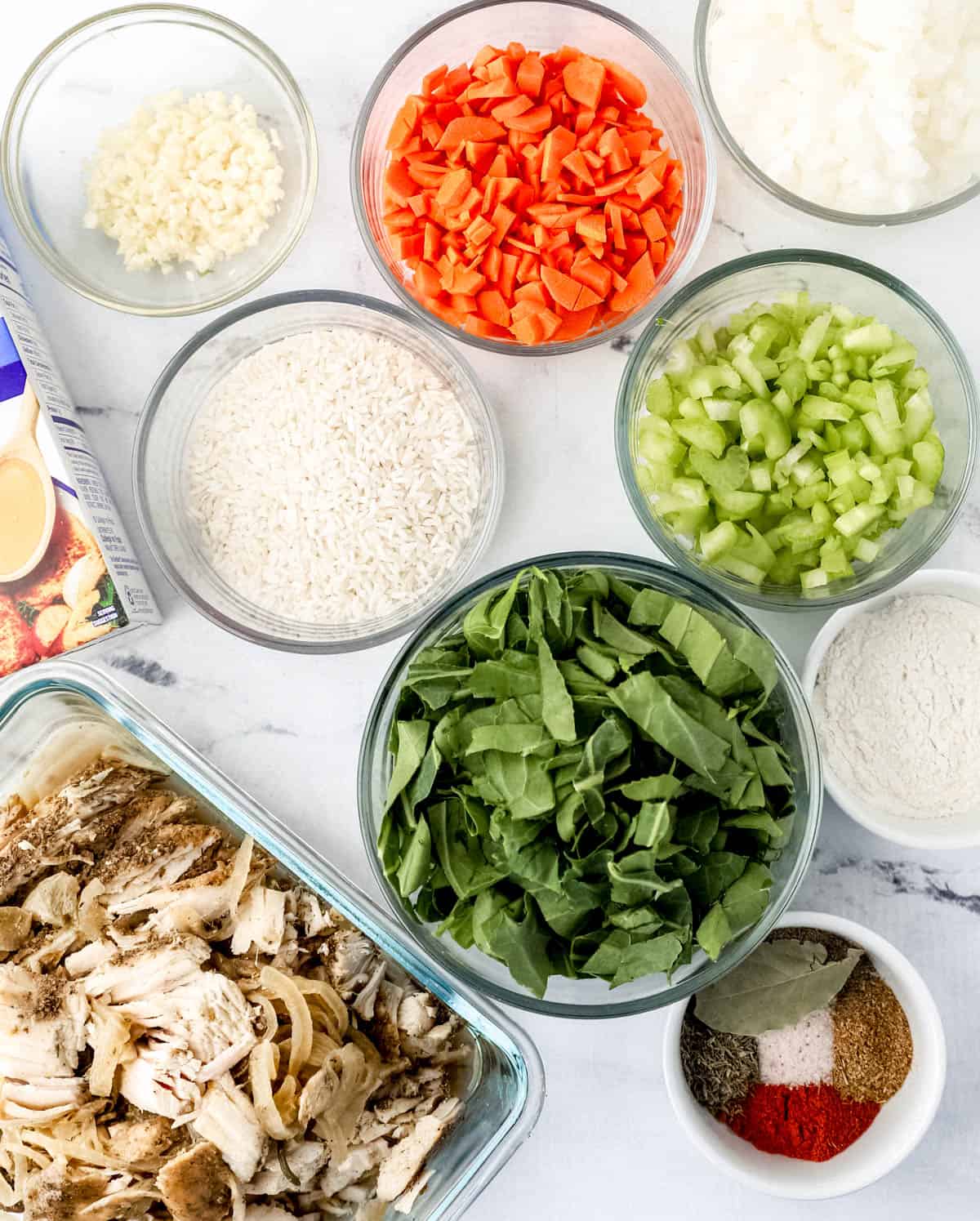 Overhead view of ingredients to make soup in separate bowls.