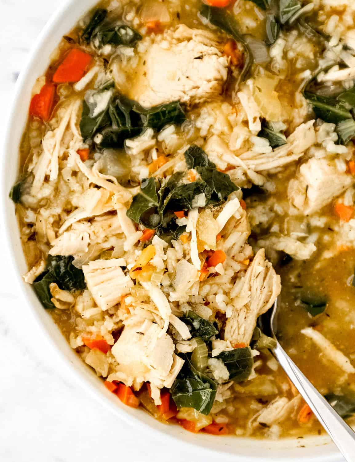 Close up view of bowl of soup with spoon in it.