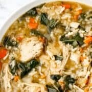 Overhead view of turkey soup in a white bowl on pin with text overlay.