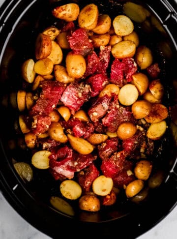 Overhead view of all ingredients added to slow cooker.