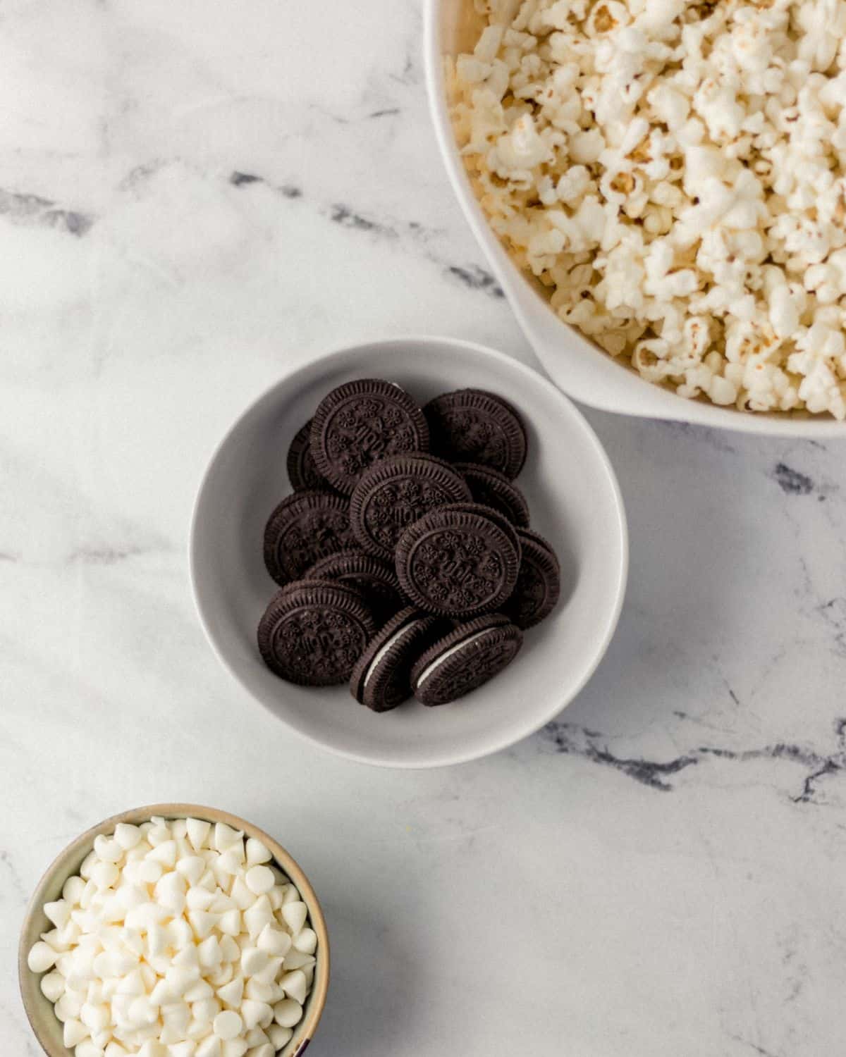 Overhead view of ingredients needed to make popcorn in separate bowls. 