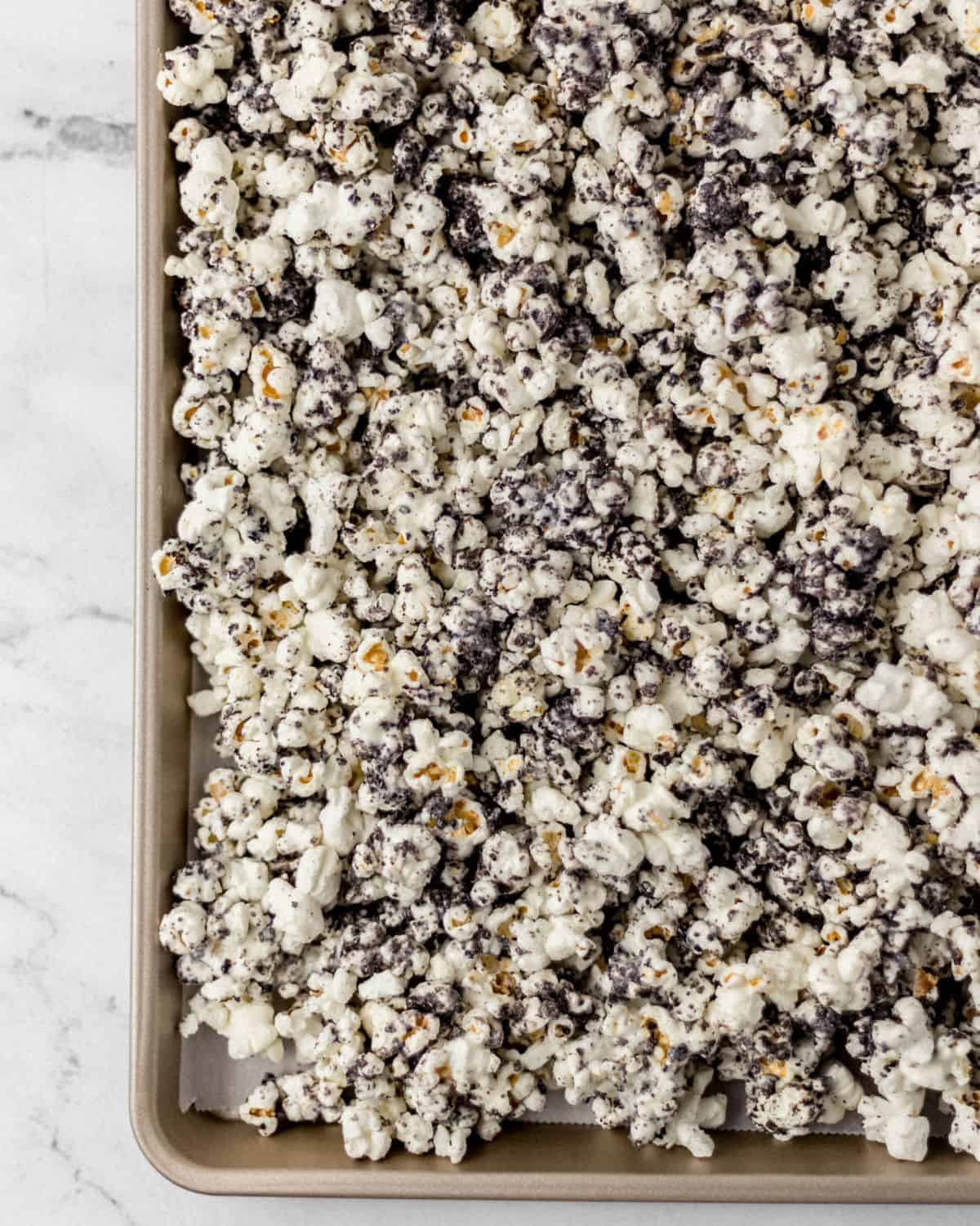 Overhead view of finished popcorn on parchment lined sheet pan. 