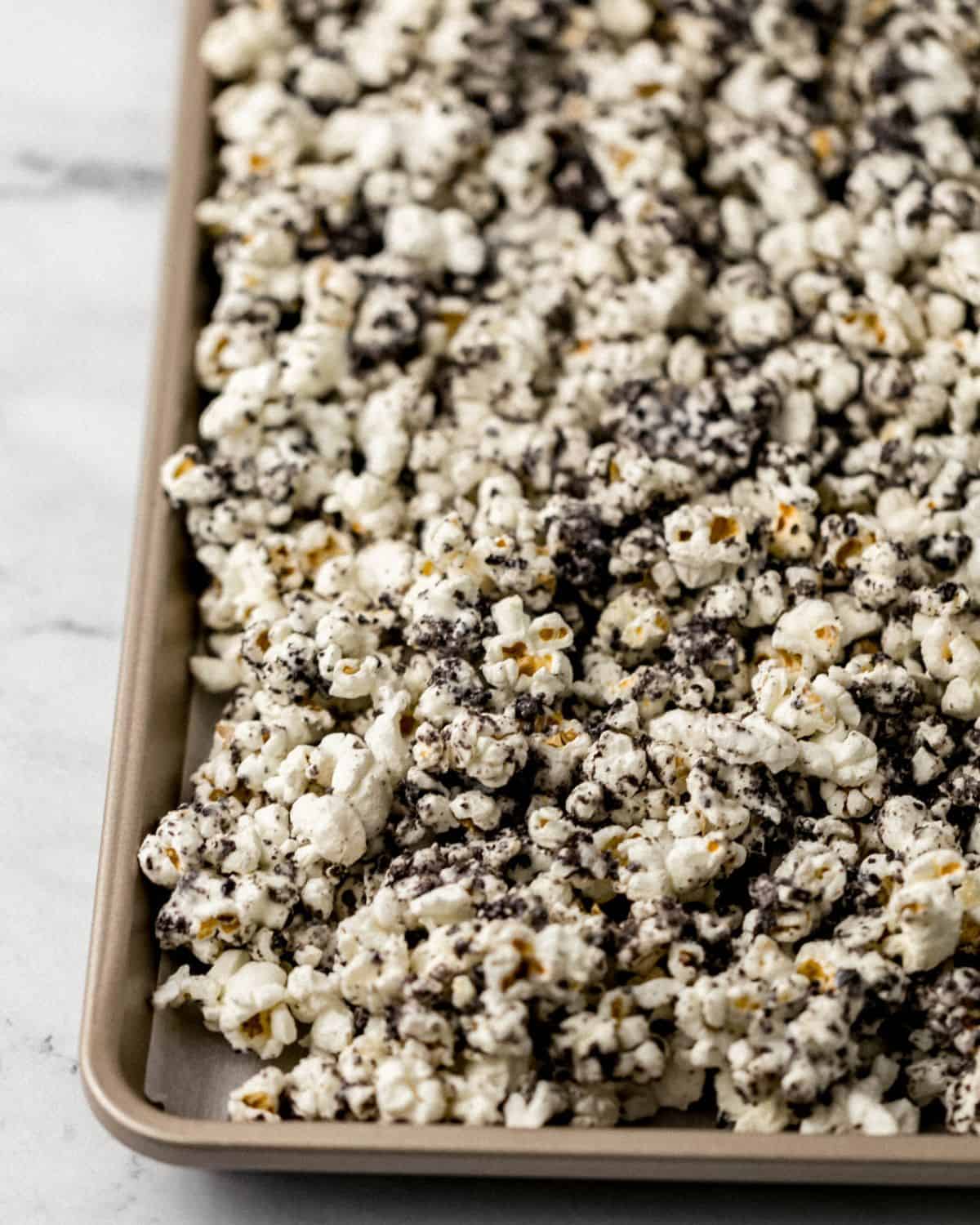 Close up front view of finished popcorn on parchment lined sheet pan. 