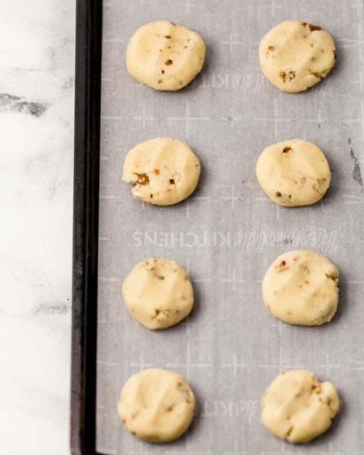 Overhead view of cookie dough on parchment lined sheet pan.