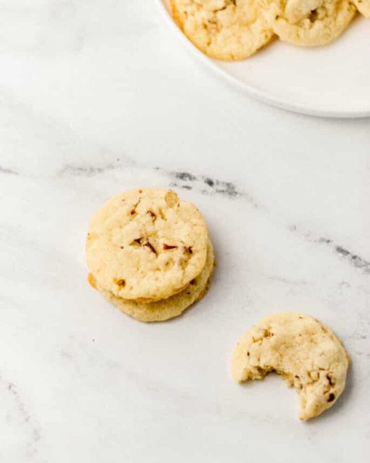 Cookies on marble surface with one with a bite out of it.